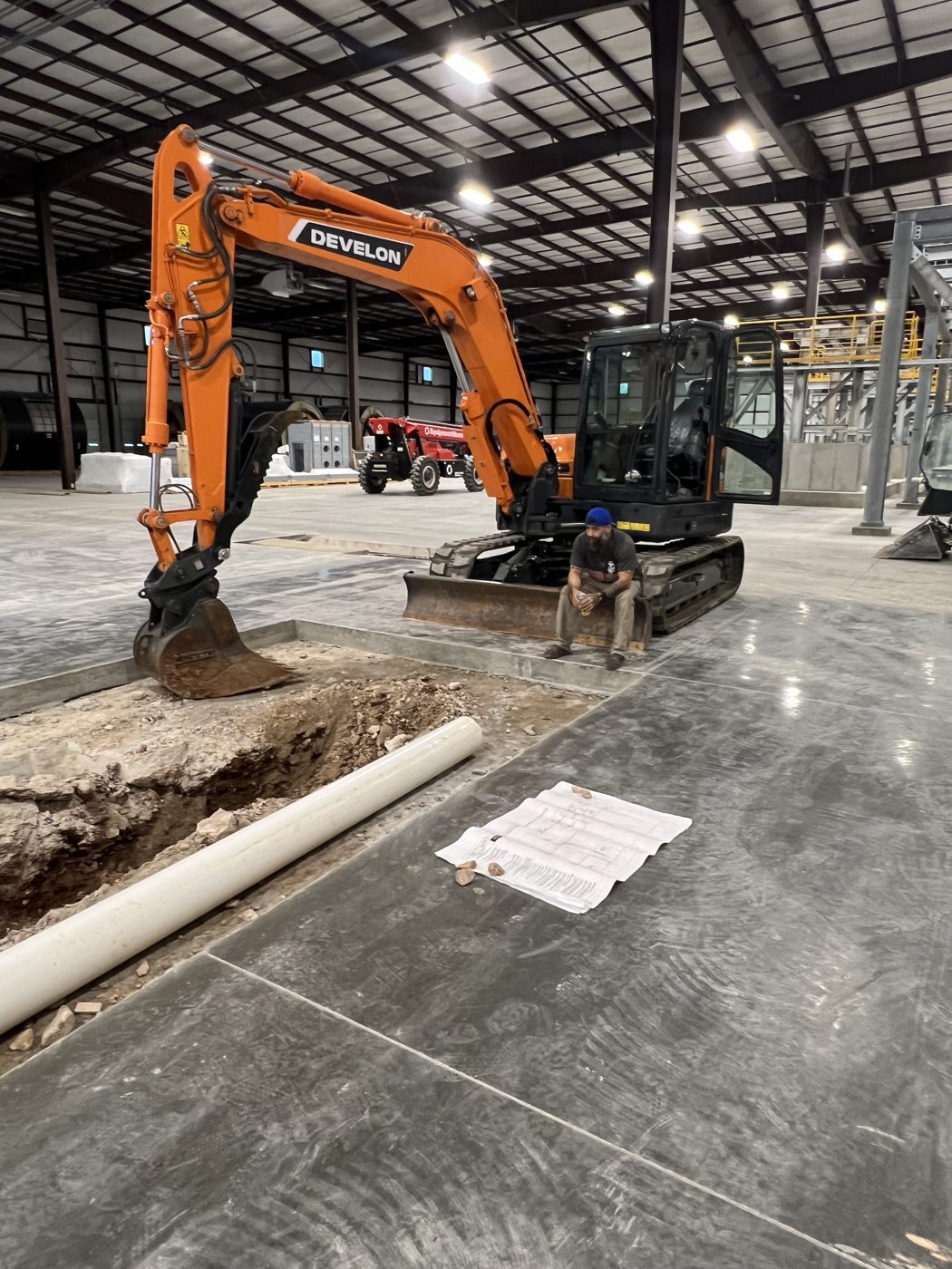 Mark on site with an excavator during underground plumbing work in a commercial building