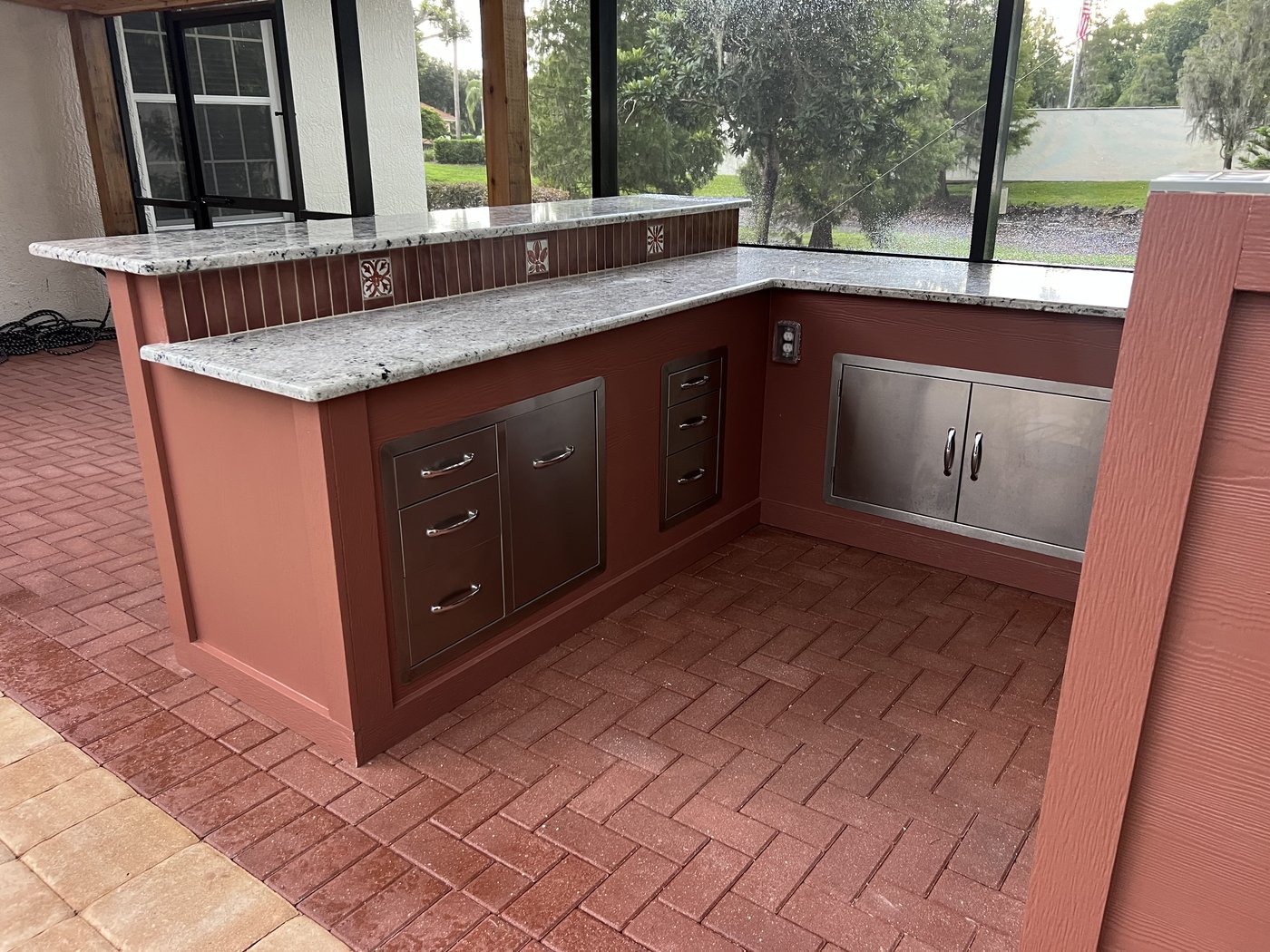 Winter Haven pool and outdoor kitchen: Finished outdoor kitchen with stained wood cabinets and granite