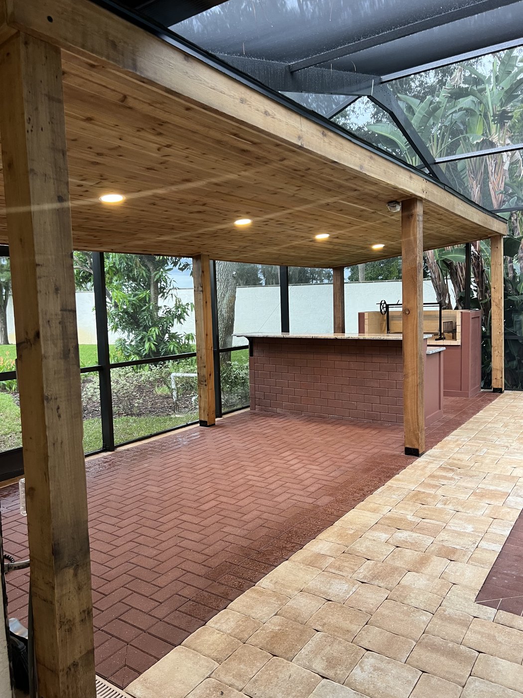 Winter Haven pool and outdoor kitchen: Covered lanai with herringbone brick and wood beams